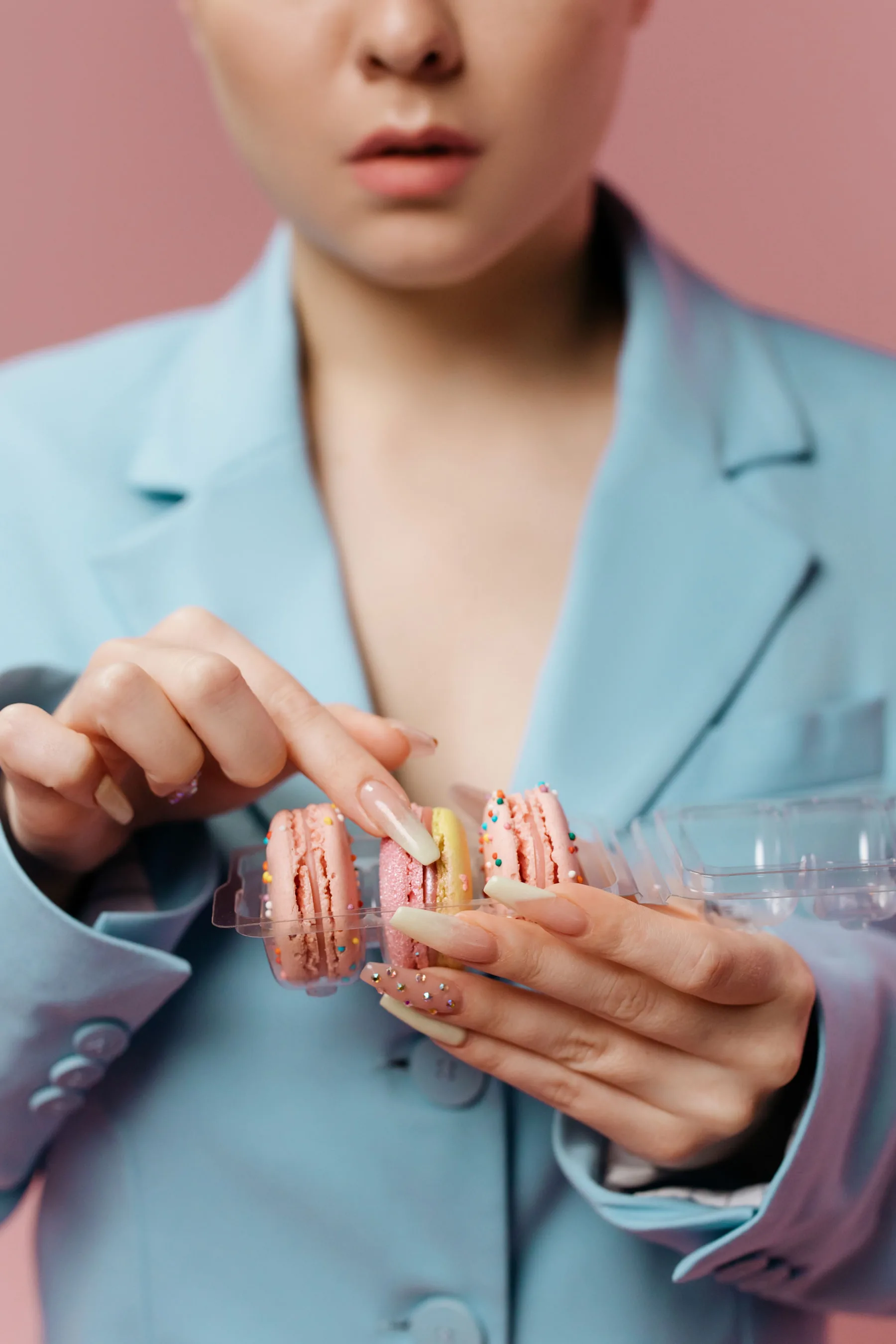Manos con uñas largas personalizadas en una composición editorial